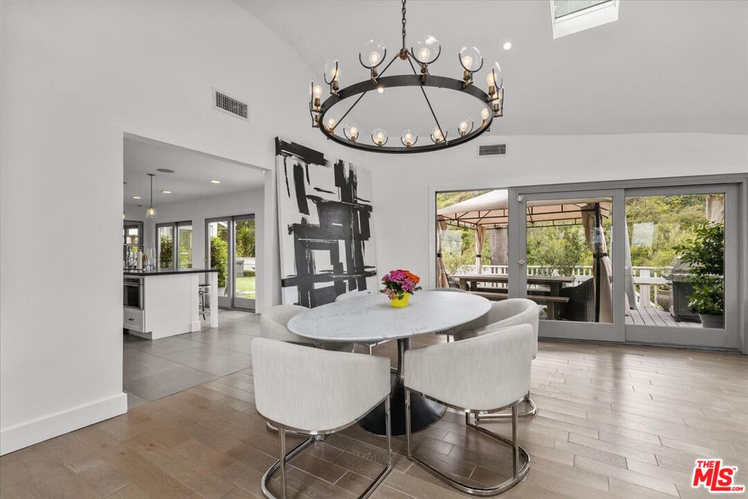 a dining room with furniture a chandelier and wooden floor