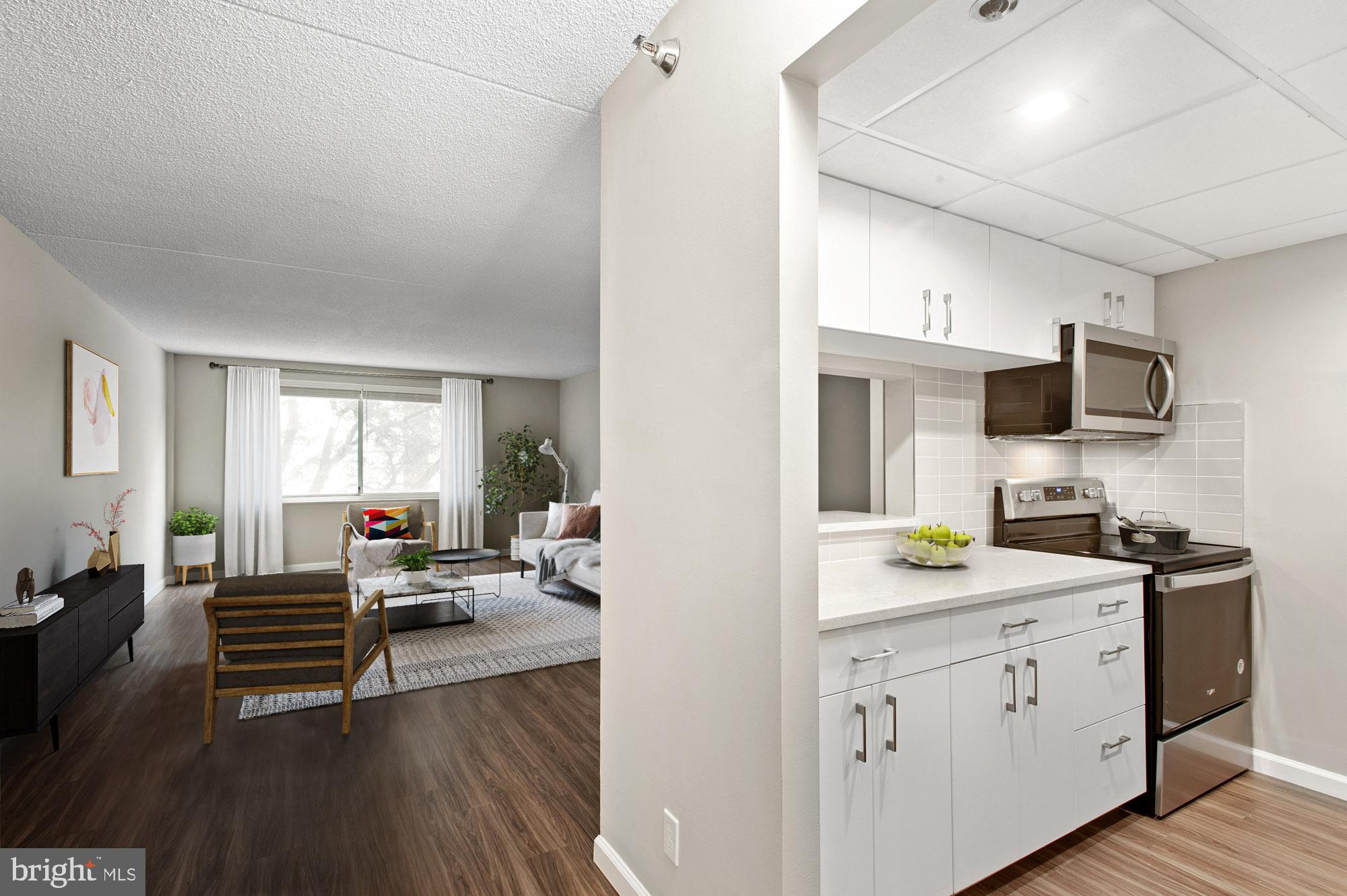 a open hall with cabinets furniture and a wooden floor