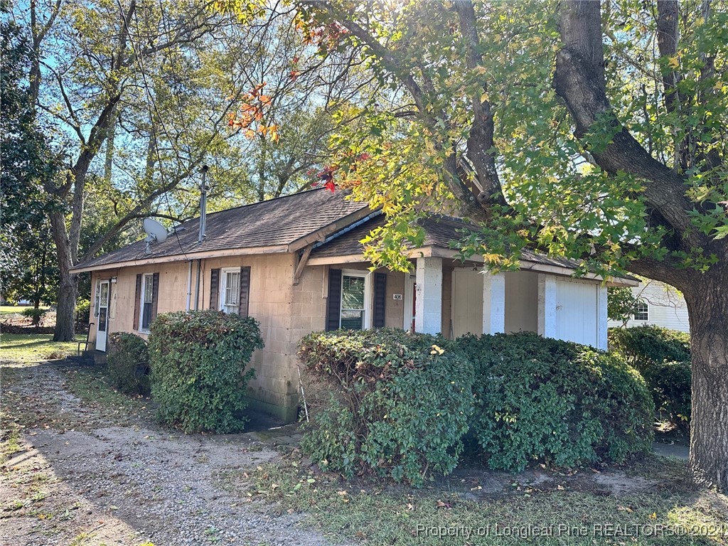 a view of a yard in front of a house with large trees