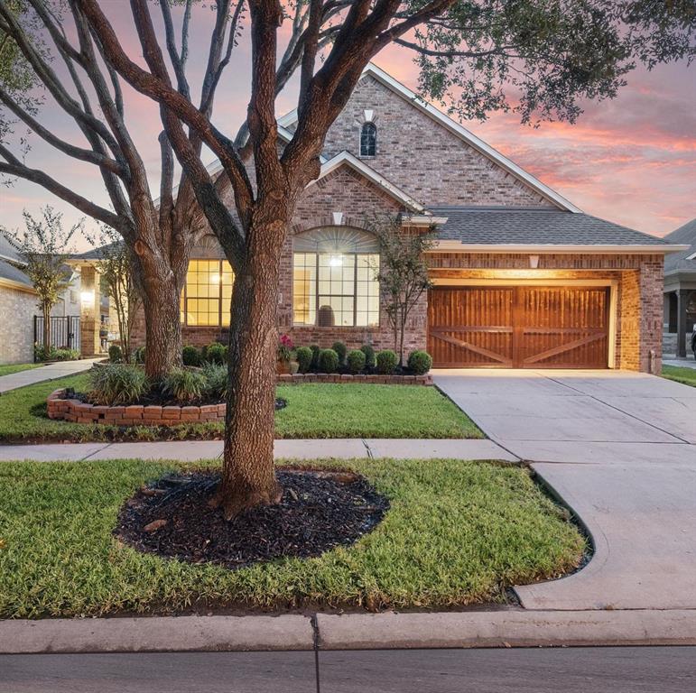 a front view of a house with a yard and potted plants