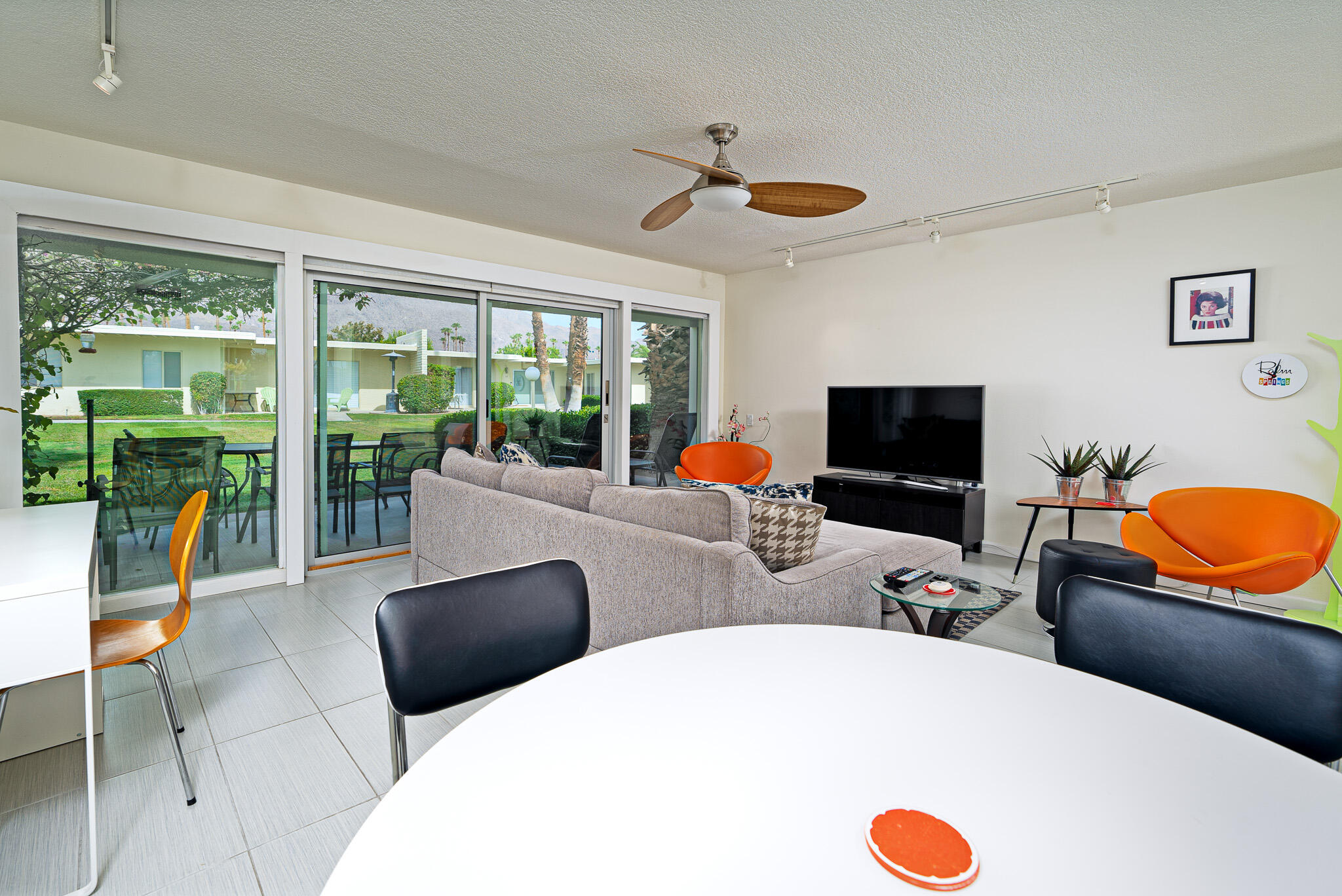 a view of a dining room with furniture a flat screen tv and a large window