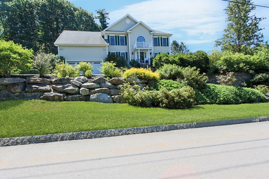 a front view of a house with a garden and plants