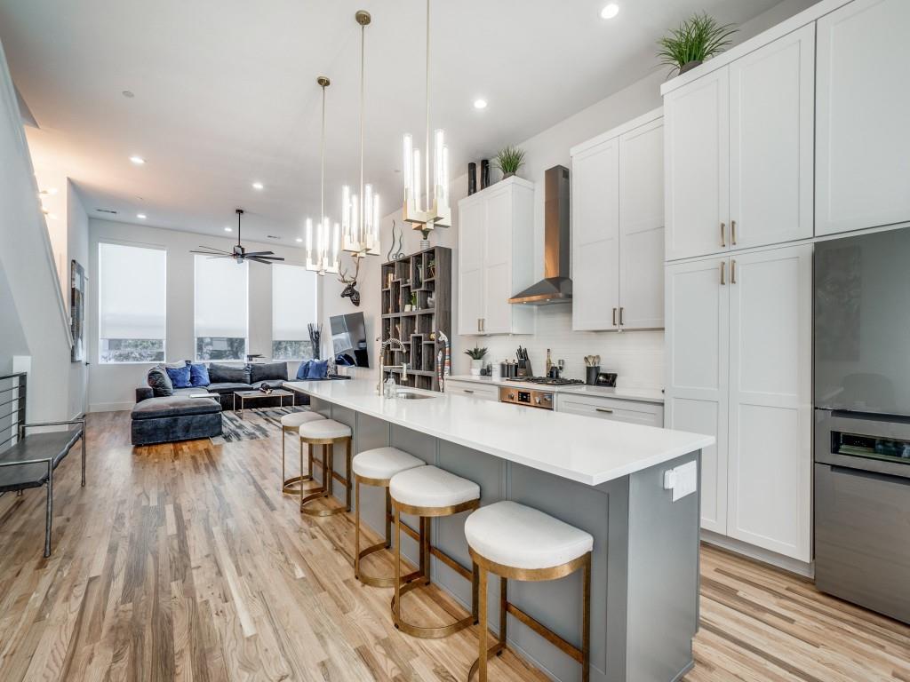 a large white kitchen with a large window and stainless steel appliances