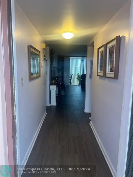 a view of a hallway with wooden floor and windows