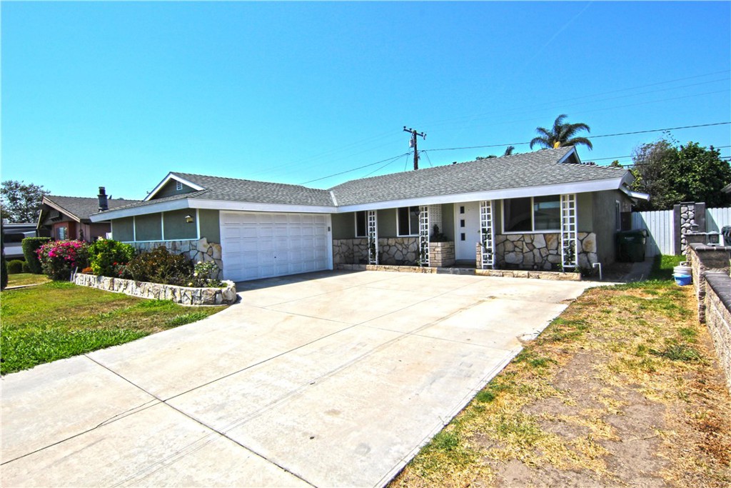 a front view of a house with a yard and potted plants