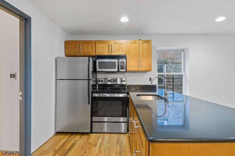 a kitchen with stainless steel appliances granite countertop a refrigerator a stove top oven a sink and dishwasher