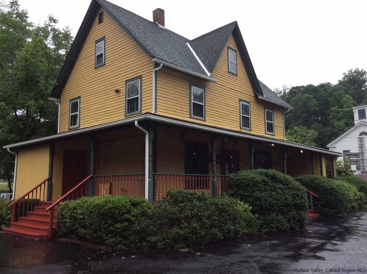 a front view of house with yard and trees in the background