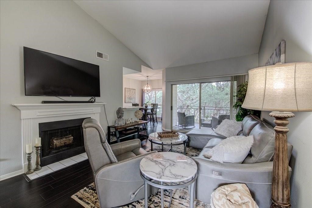 a living room with furniture a fireplace and a flat screen tv