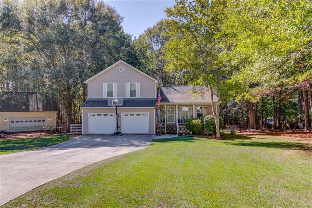 a front view of a house with a yard and trees