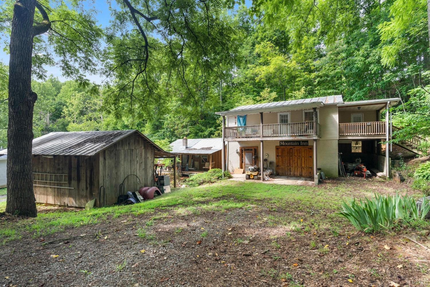 a view of a house with a yard and large tree