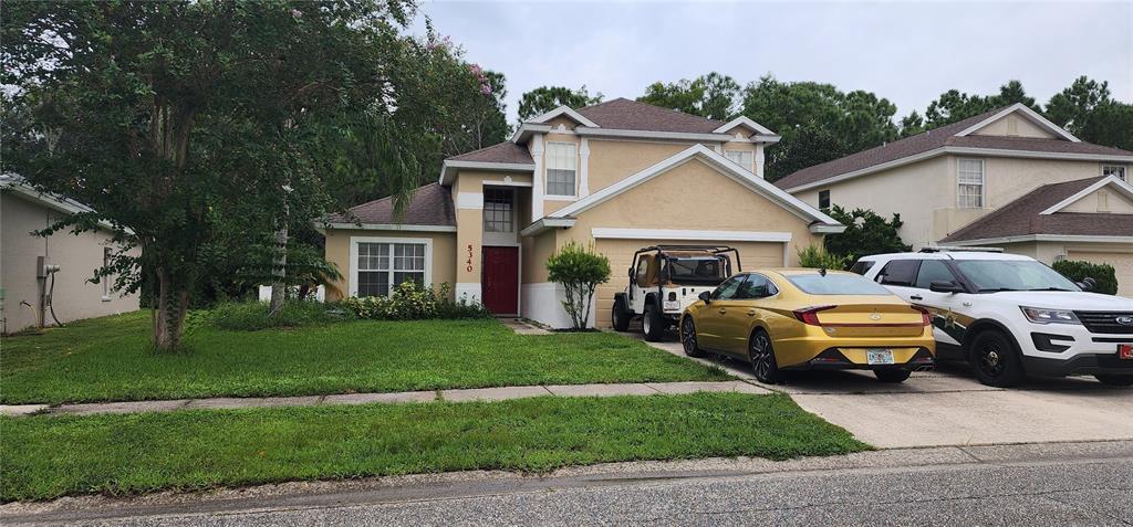 a front view of a house with a garden and parking