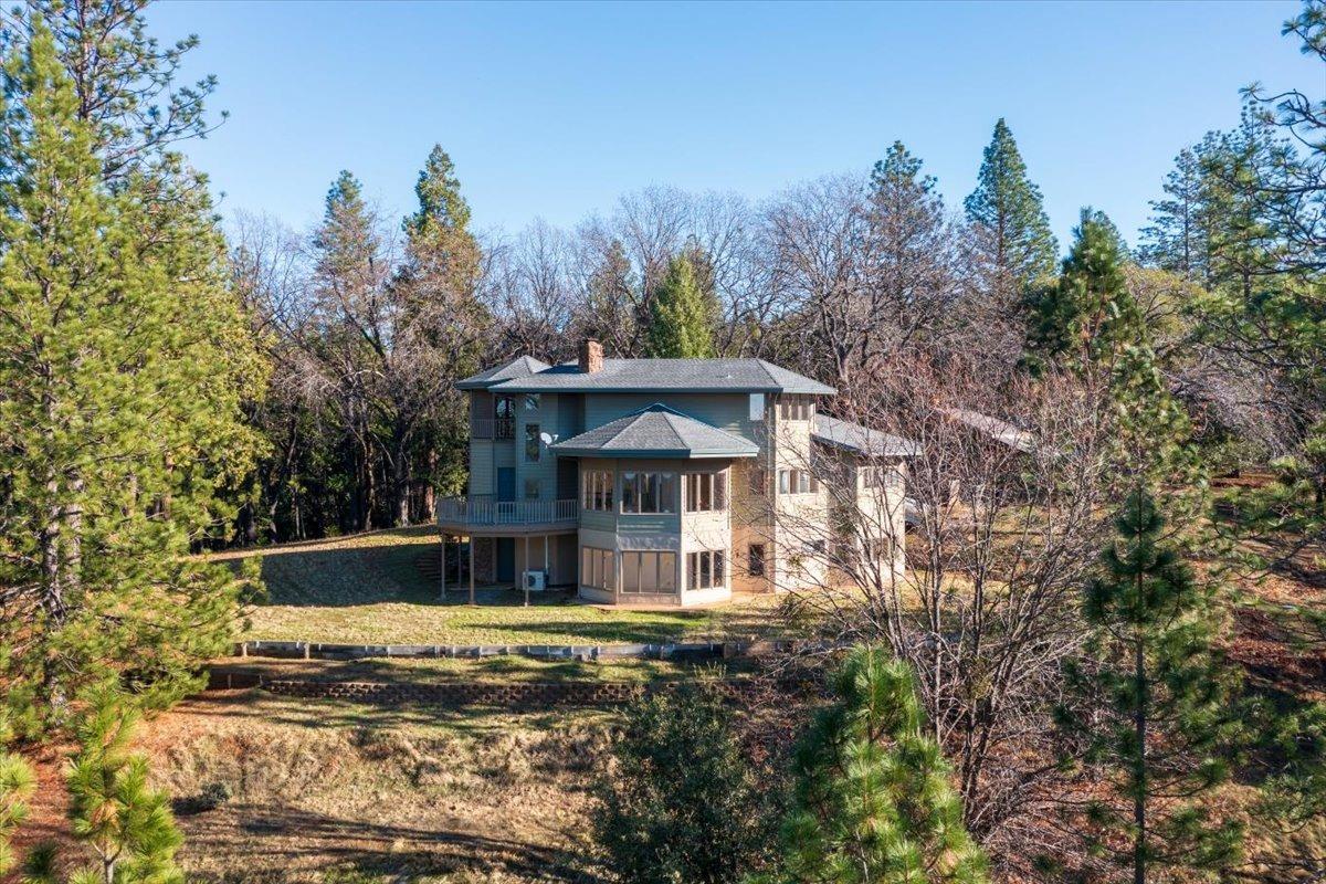 a view of a house with a yard balcony and trees