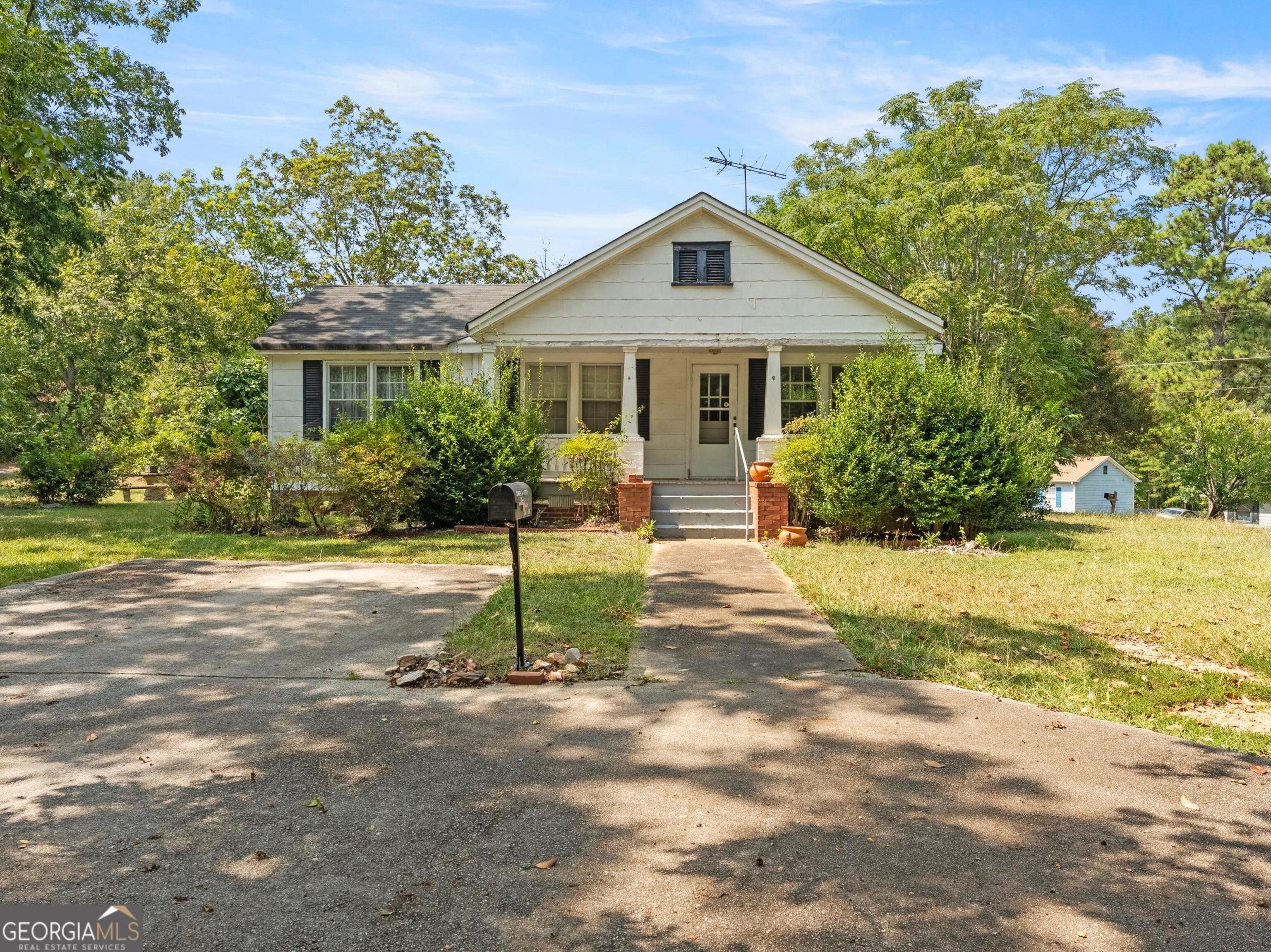 a front view of a house with a yard and potted plants