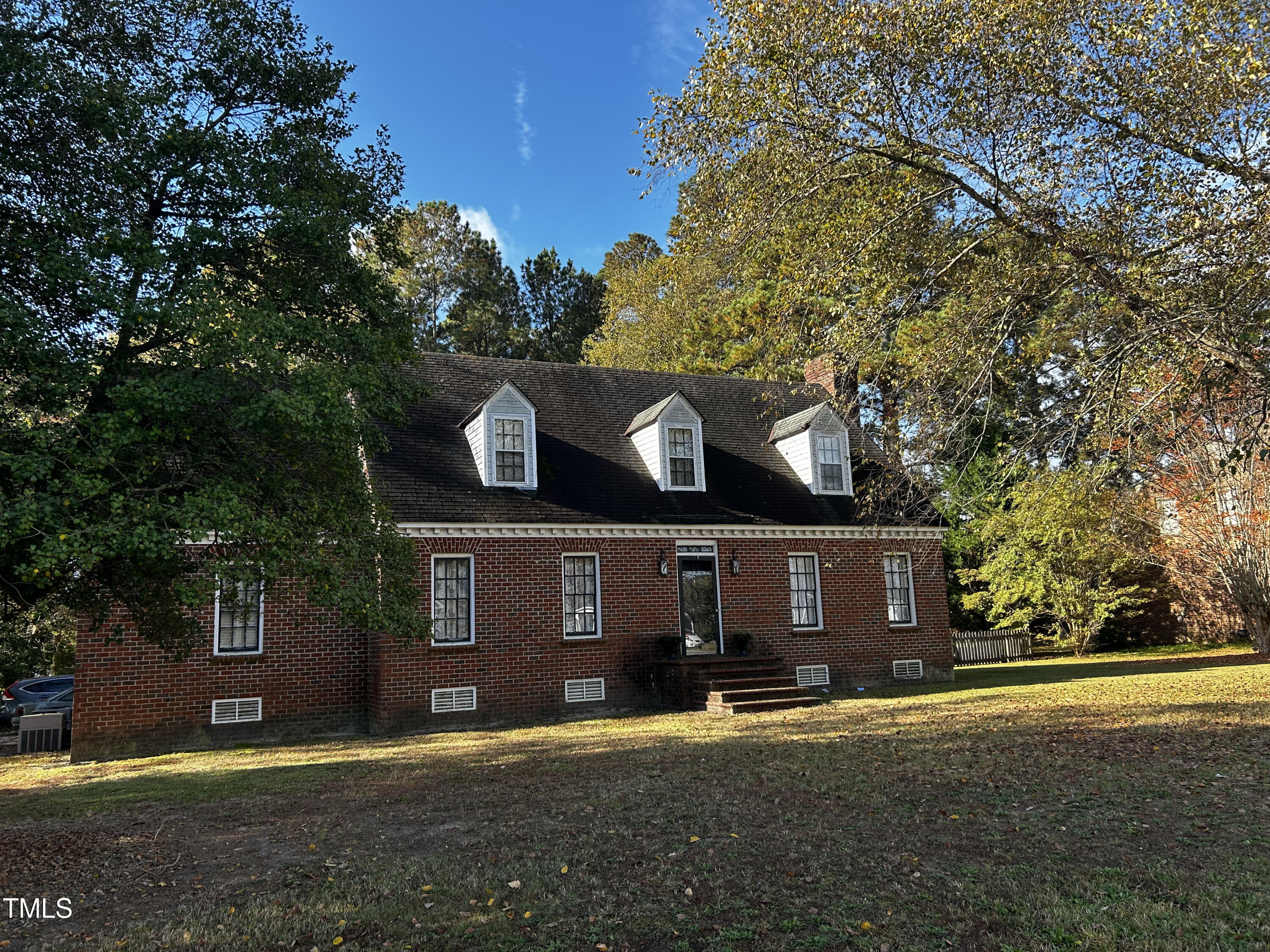 front view of a house with a yard and a large tree