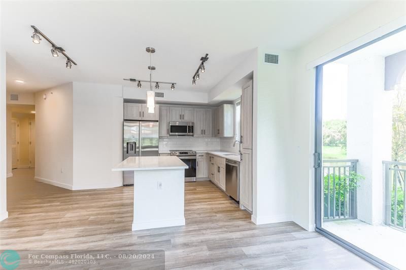 a view of a kitchen with cabinets and wooden floor