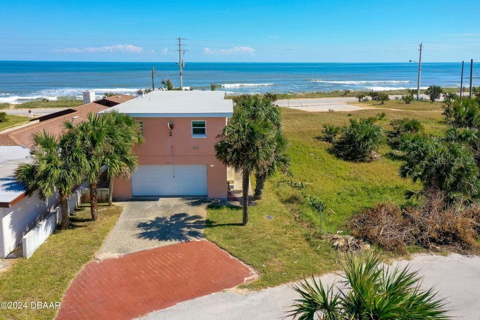 a view of a house with a yard and ocean view