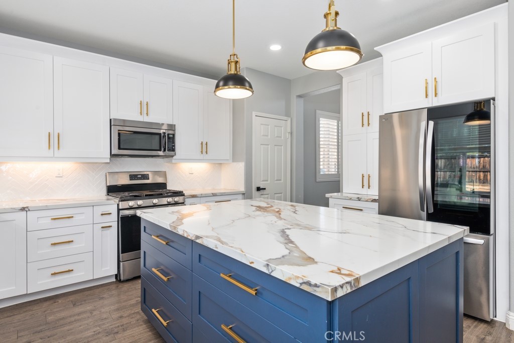 a kitchen with granite countertop a sink stove and refrigerator