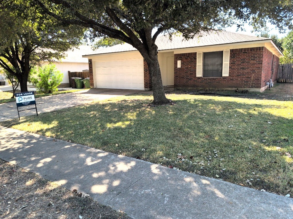 a view of a yard in front of a house with large tree