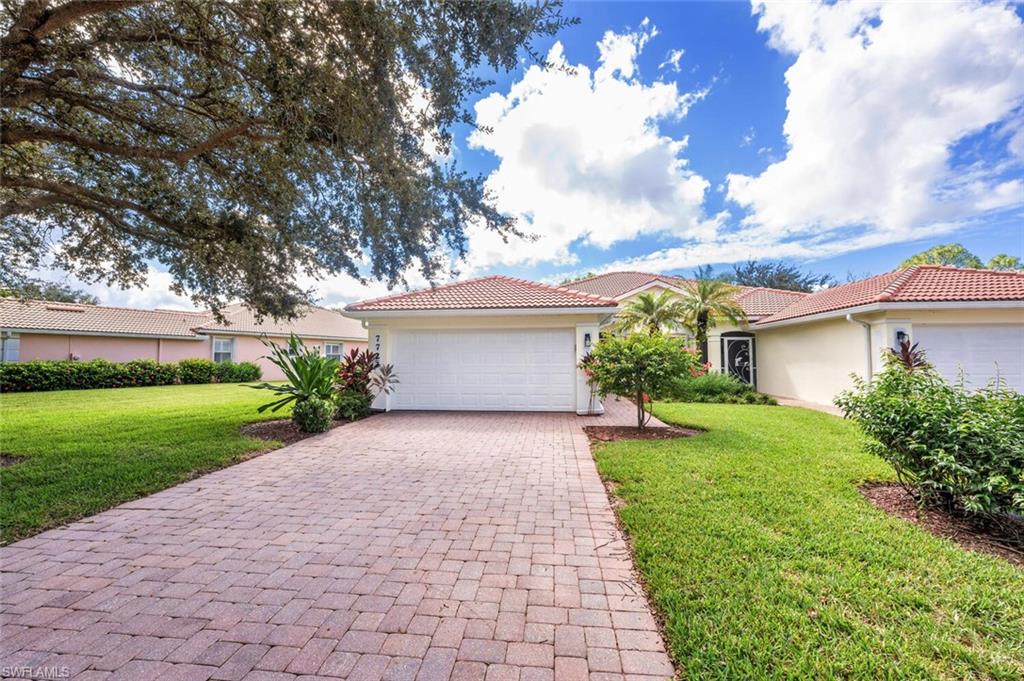 Single story home featuring long driveway and a garage