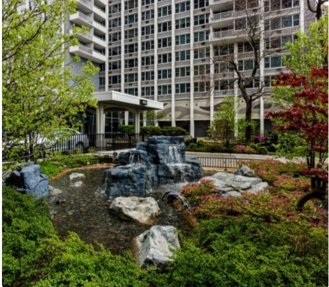 front a large building with multiple trees