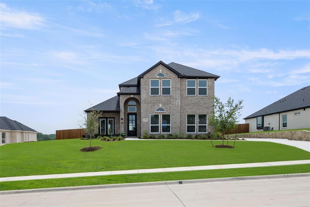 a front view of a house with a yard and trees