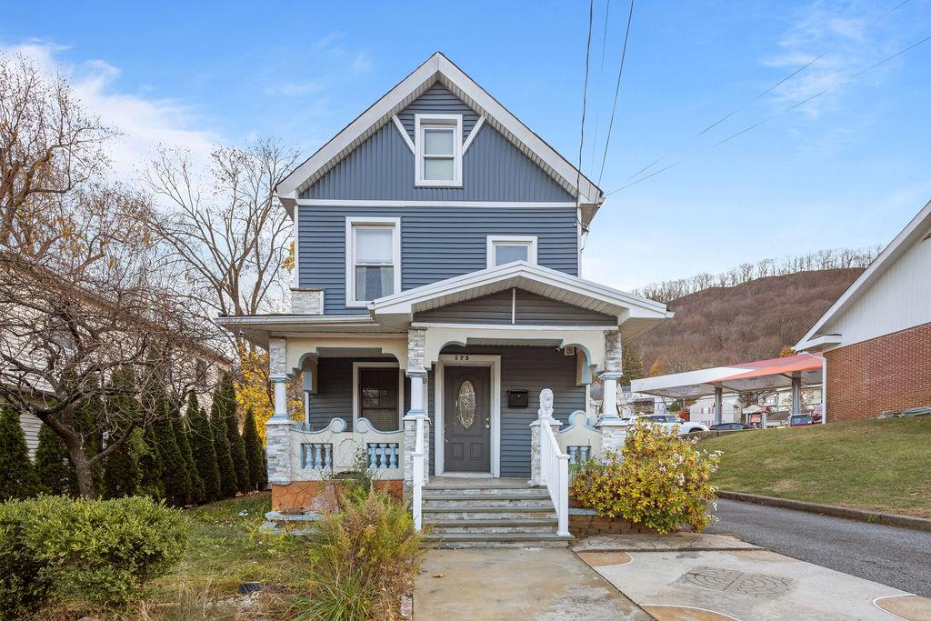 View of front of house featuring covered porch and a front lawn