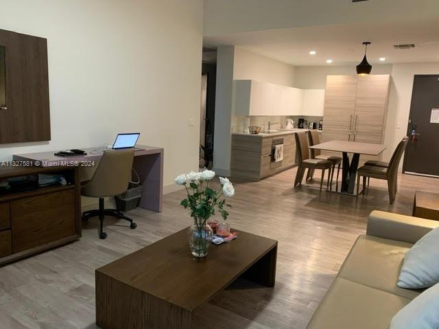 a living room with furniture kitchen view and a piano