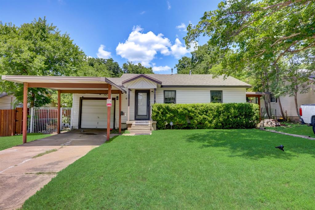 Single story home with a garage, a front yard, and a carport