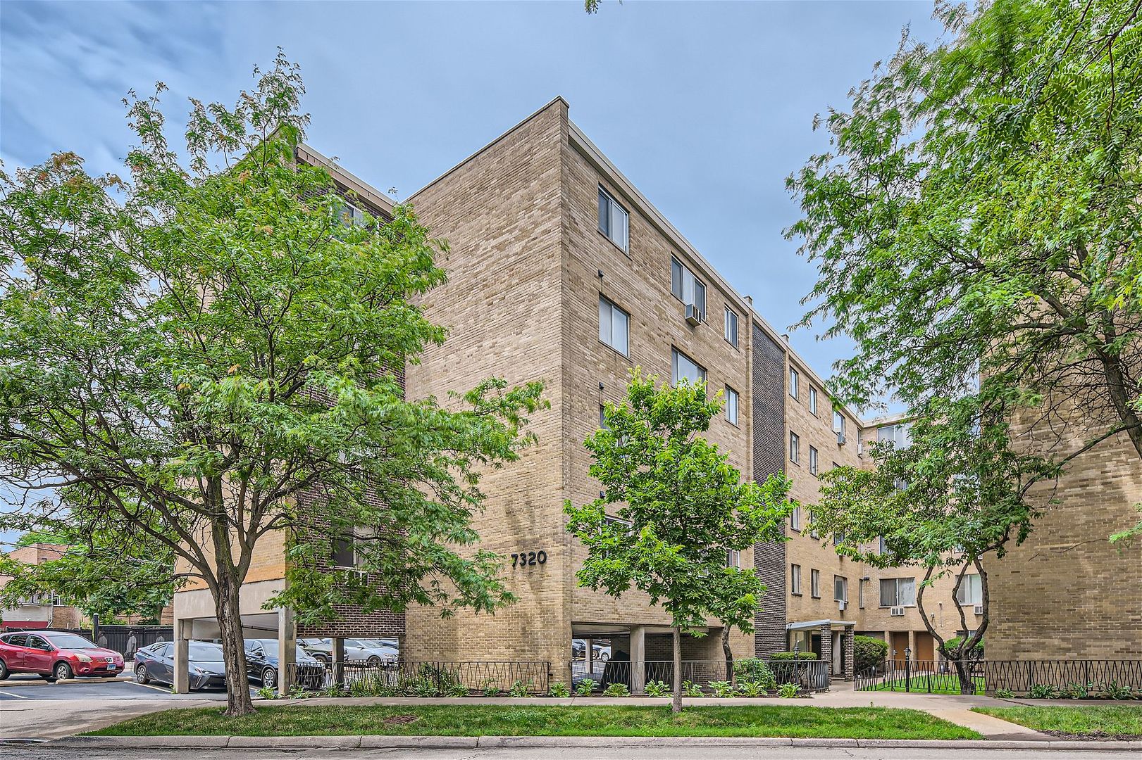 a front view of a building with trees