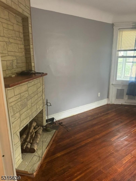 a room with wooden floor and a fireplace