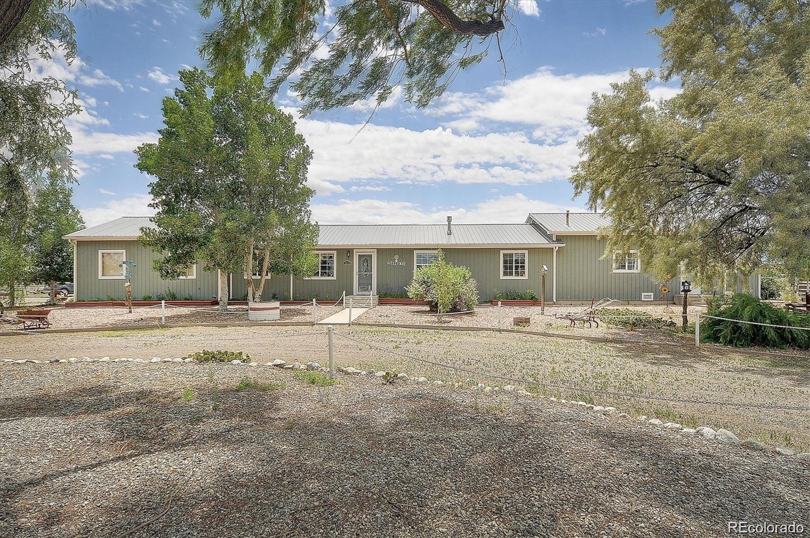 a view of a house with a yard and large tree