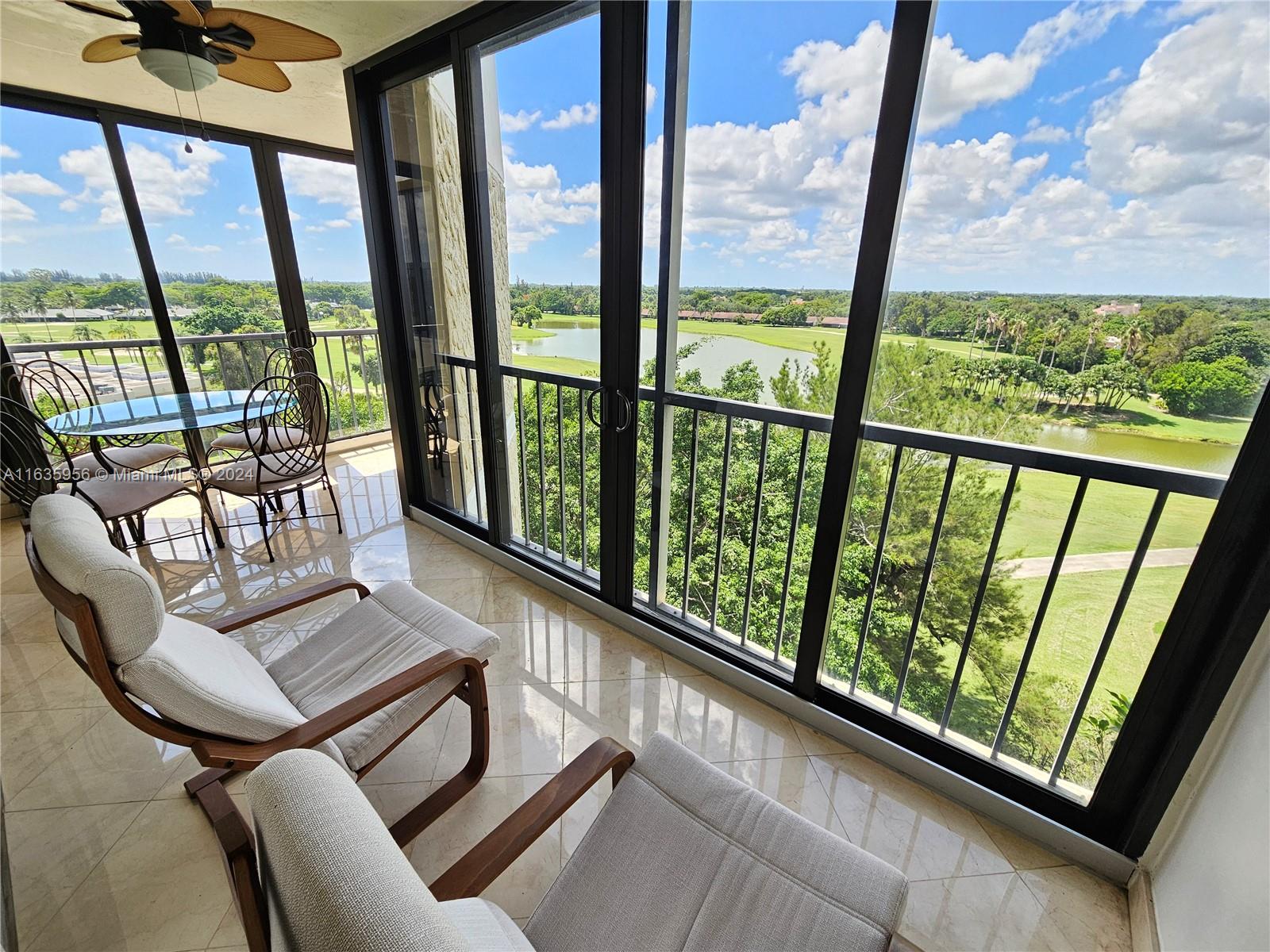 a view of a living room with furniture and floor to ceiling windows