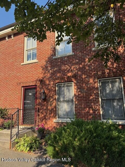 front view of a brick house with a small yard