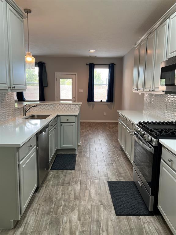 a kitchen with stainless steel appliances granite countertop a sink stove and cabinets