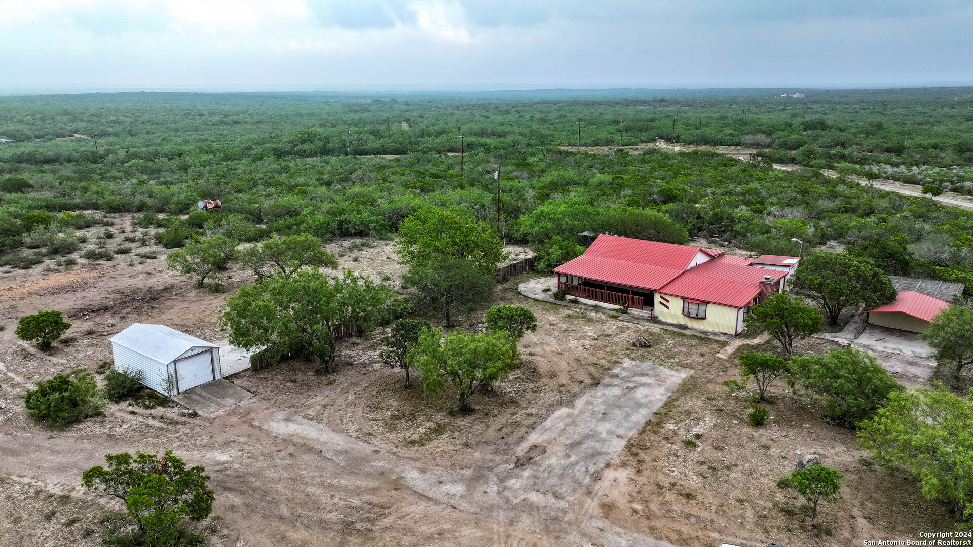 an aerial view of a house with a yard and lake view