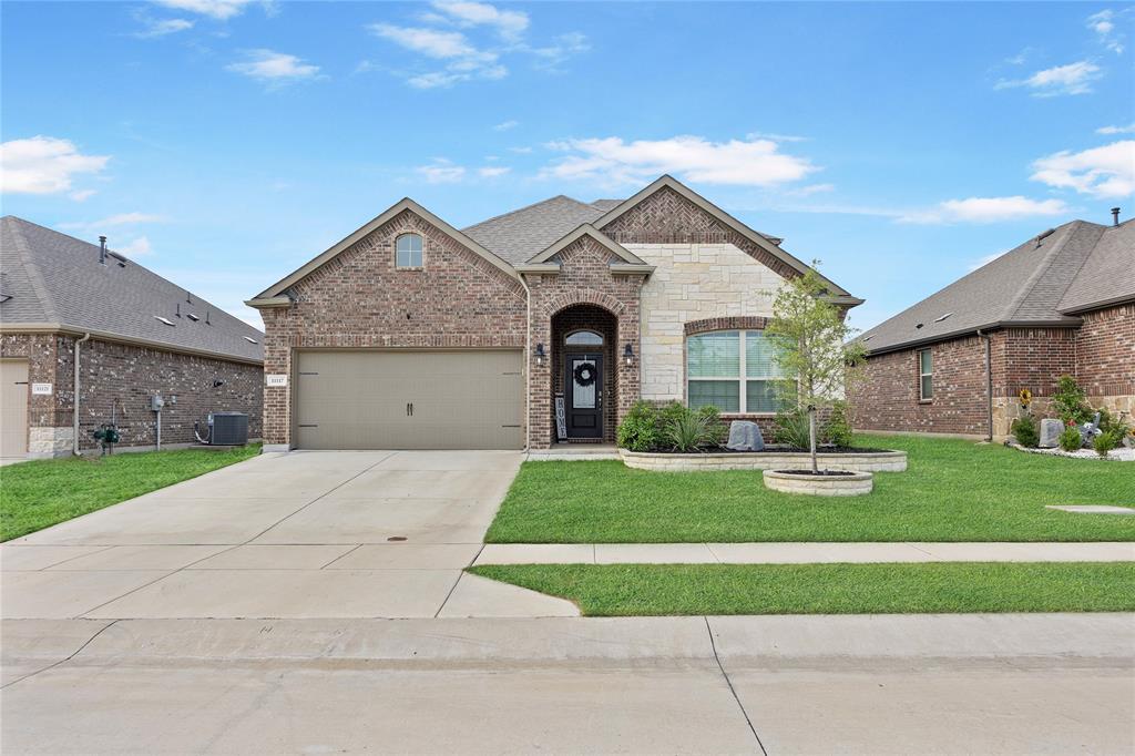 a front view of a house with garage and yard