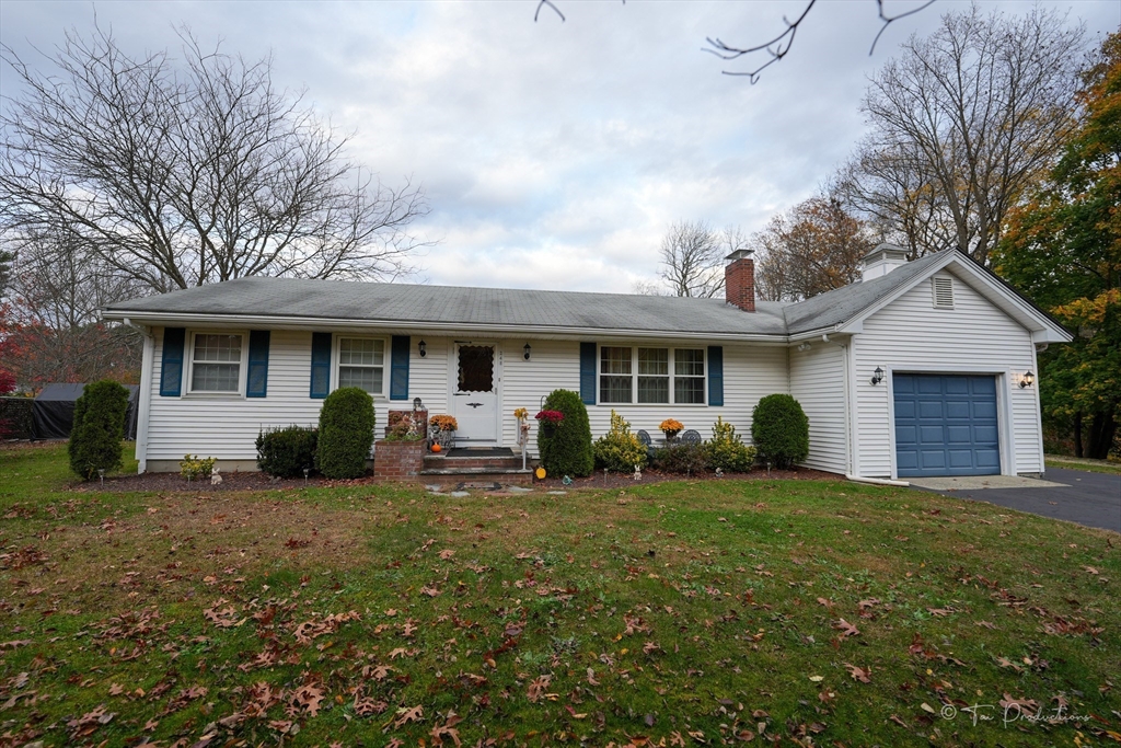 a view of a house with a yard and large trees