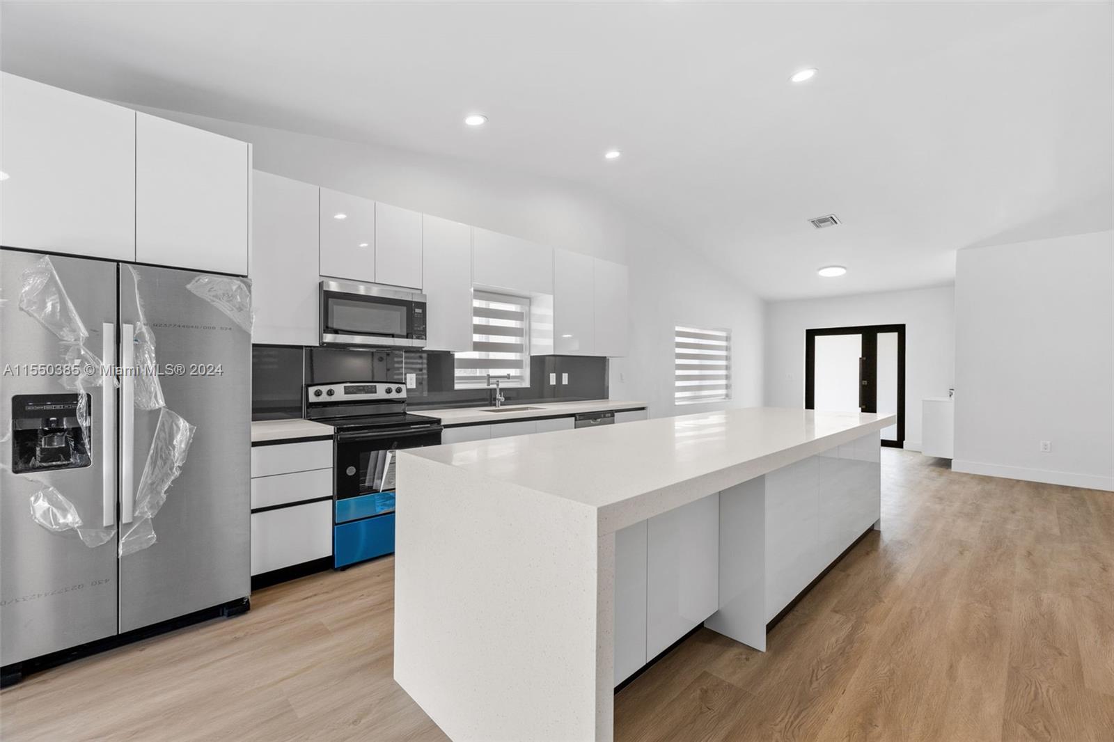 a kitchen with white cabinets and stainless steel appliances