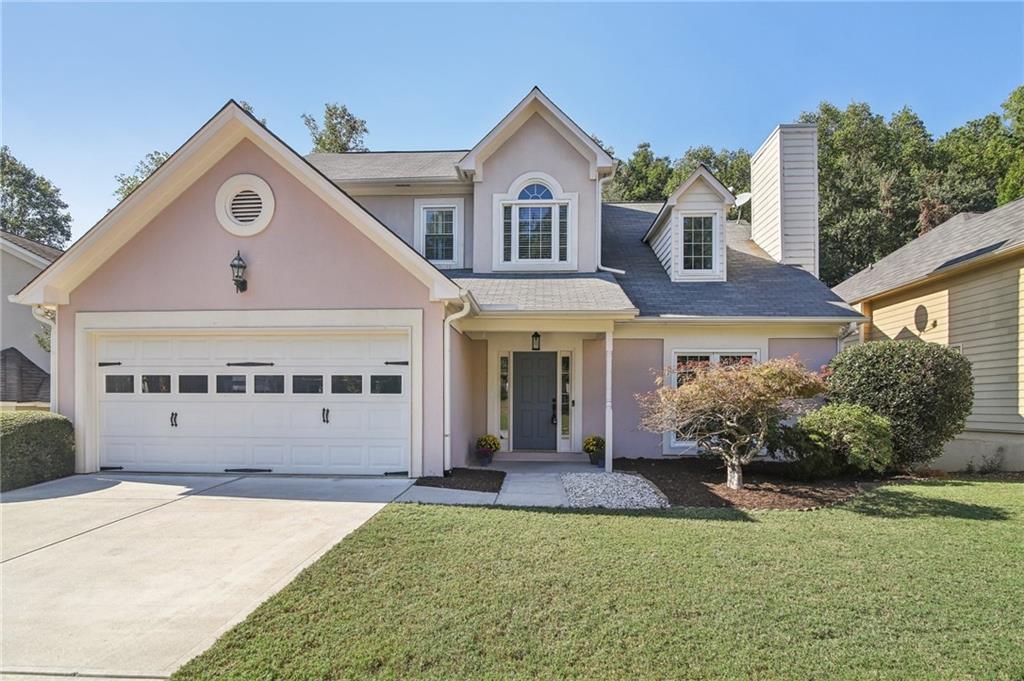 a front view of a house with a yard and garage