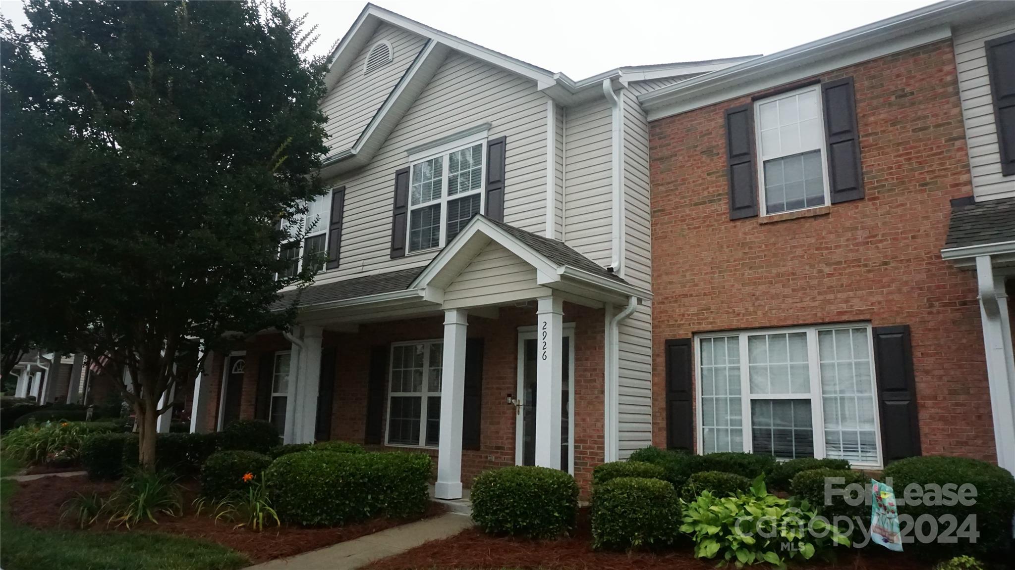 front view of a brick house with a yard