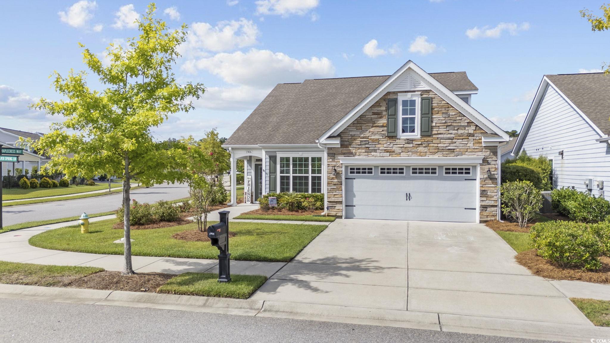 View of front of home with a garage and a front la