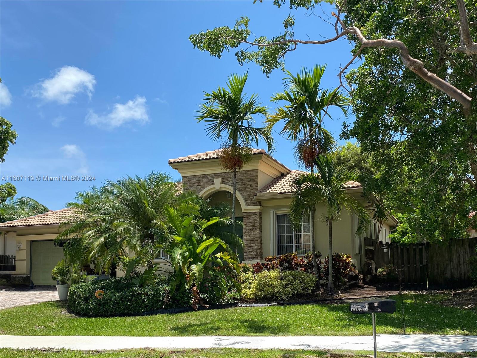 a front view of a house with a yard and potted plants