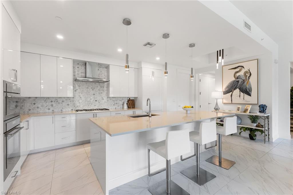 a kitchen with appliances a sink and cabinets