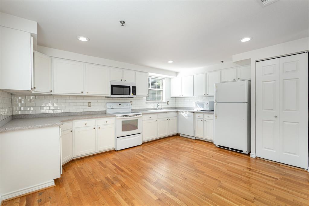 a kitchen with white cabinets and white appliances