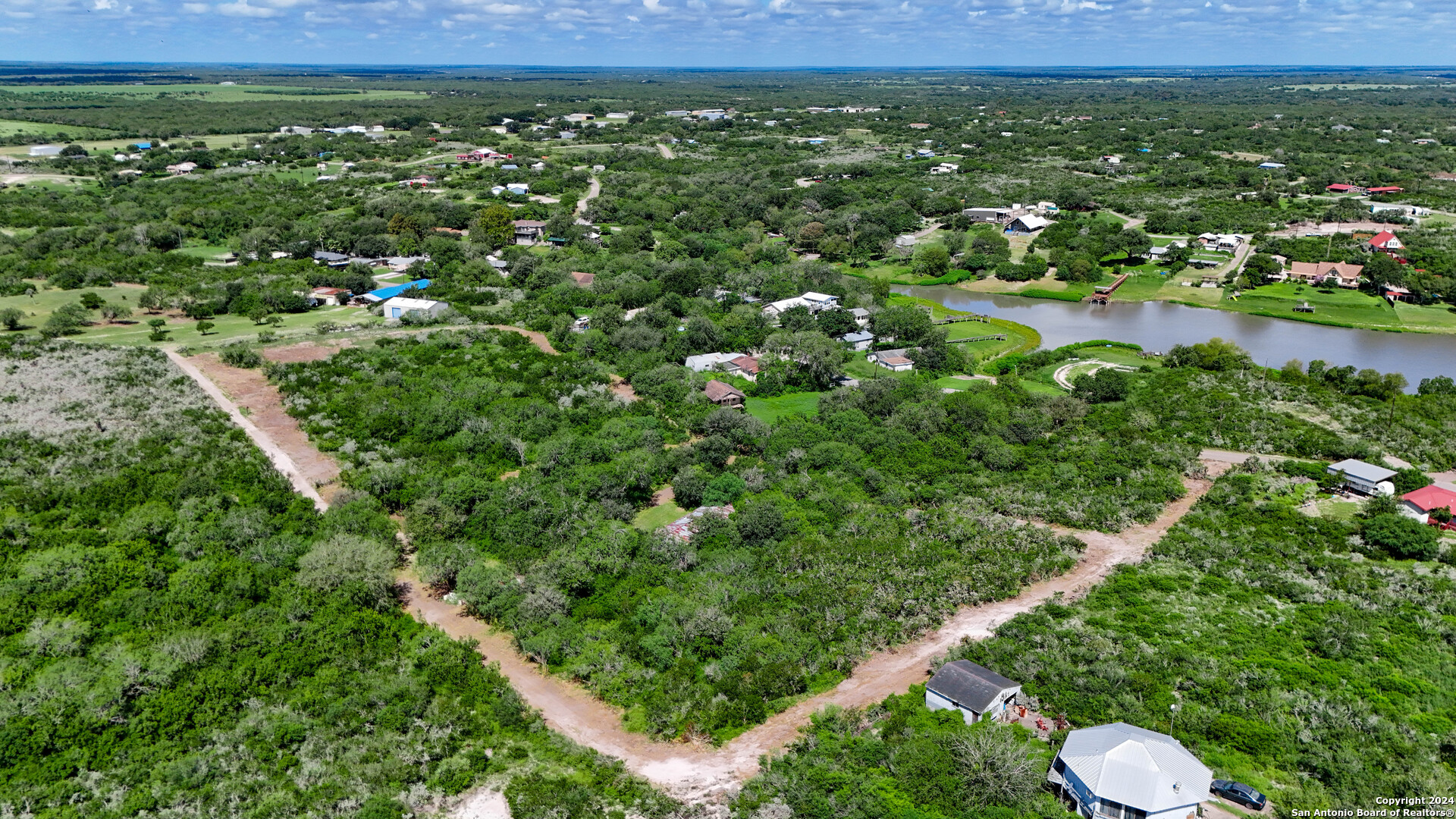 a view of a green field with lots of bushes