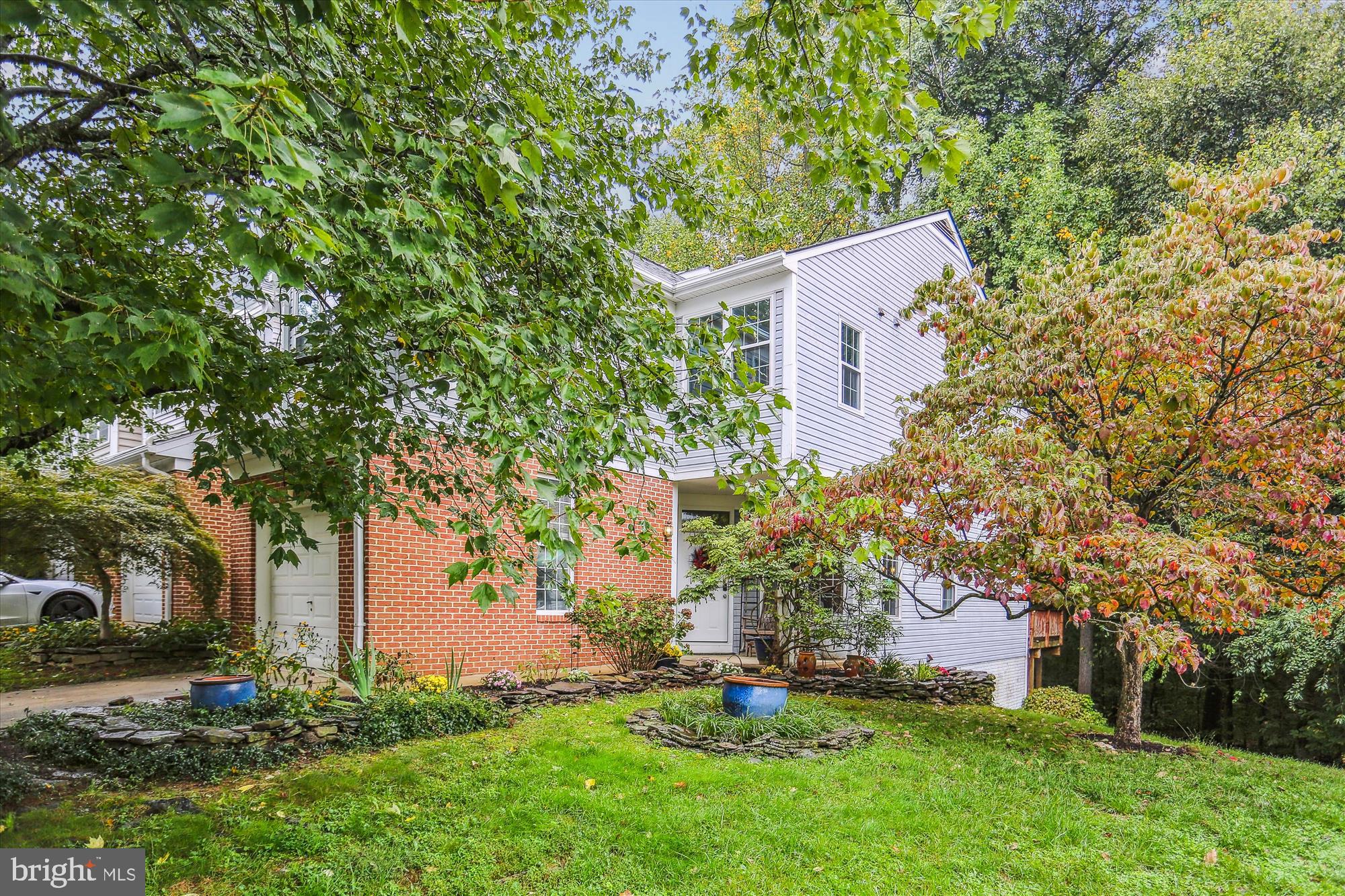 front view of a house with a yard and an trees