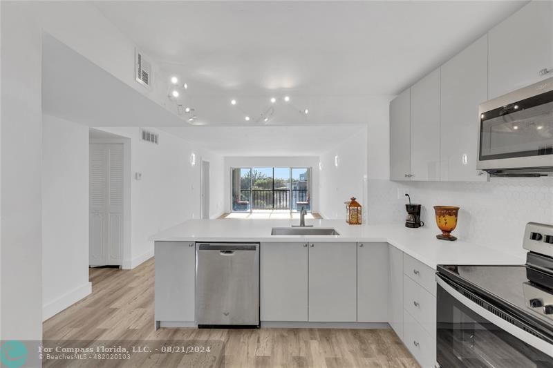 a kitchen with stainless steel appliances granite countertop a sink and a stove