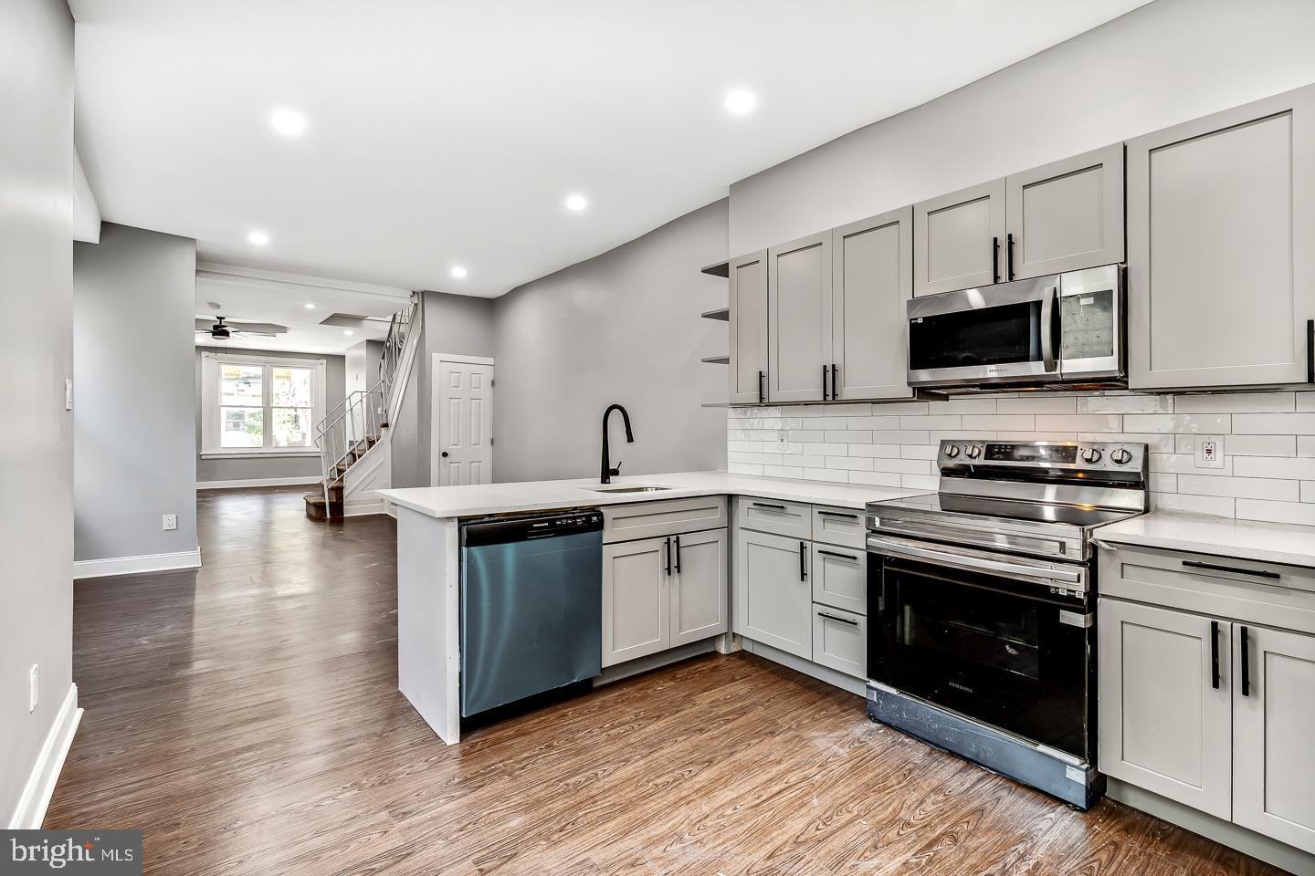 a kitchen with granite countertop a stove top oven sink and cabinets