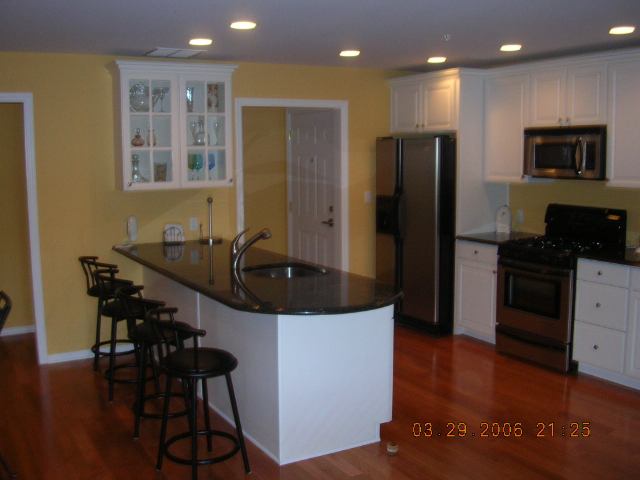 a kitchen with kitchen island stainless steel appliances a sink and a refrigerator