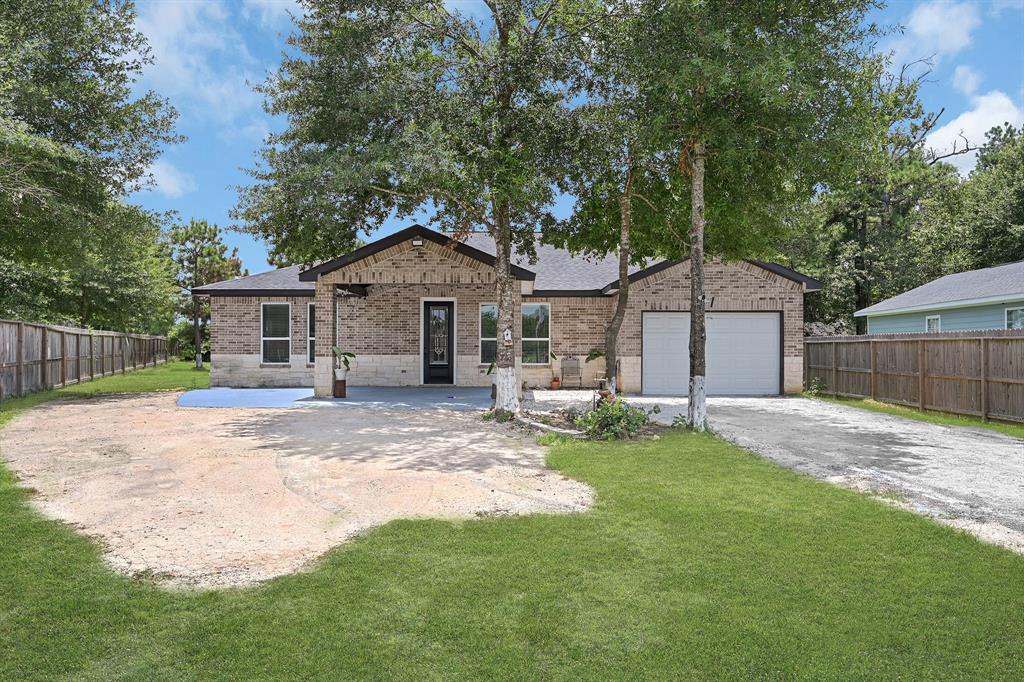 a front view of a house with a garden and trees